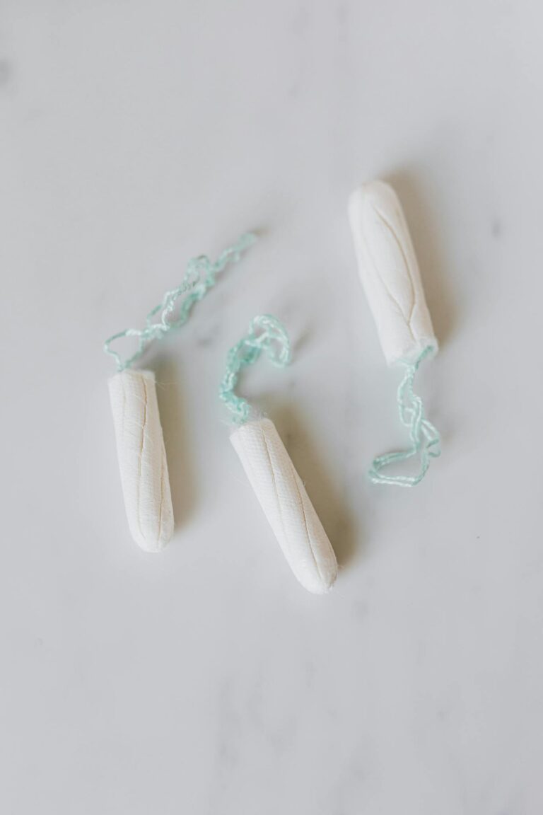 Minimalistic image of unused white tampons on a marble surface, perfect for period product themes.